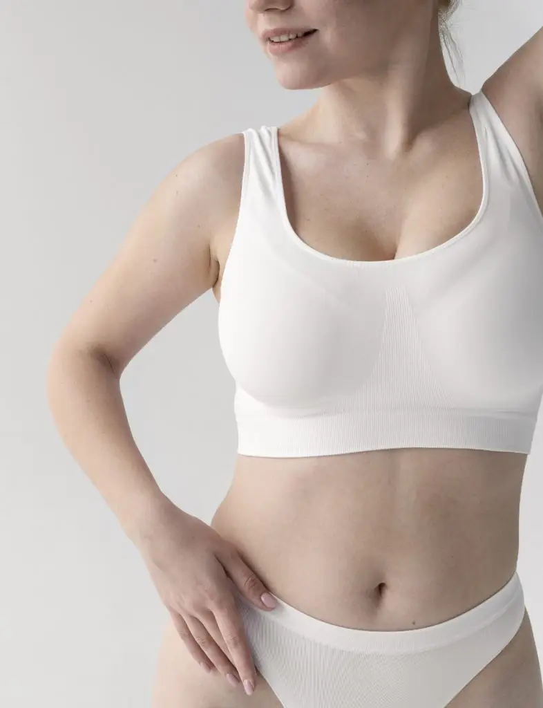Woman in white underwear showing a flat, toned tummy